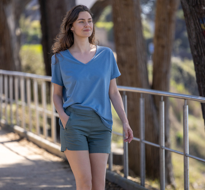 Femme portant un short blanc et un polo vert à manches courtes