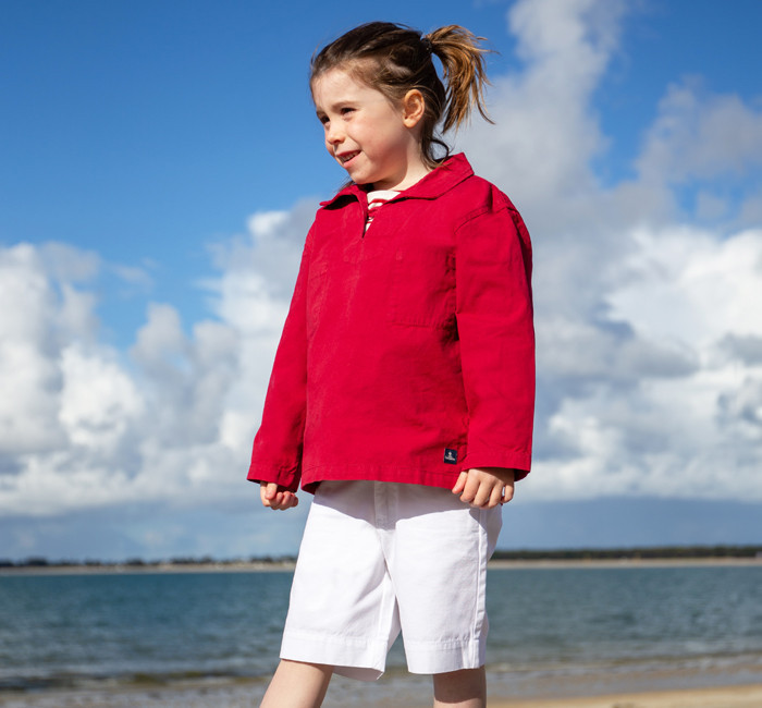 Child wearing a red cotton canvas fisherman smock